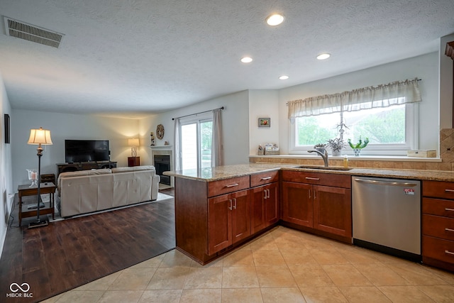 kitchen with light stone countertops, a sink, recessed lighting, stainless steel dishwasher, and visible vents