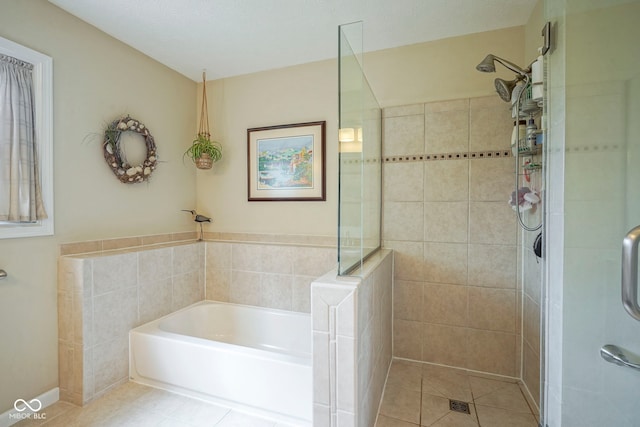 bathroom featuring tile patterned flooring, a garden tub, and tiled shower