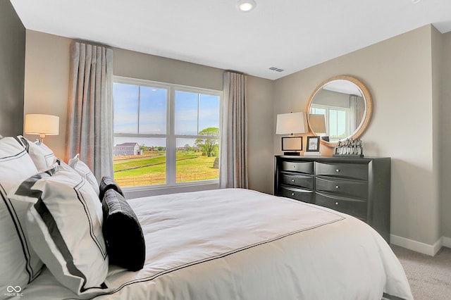 bedroom with carpet floors, baseboards, visible vents, and multiple windows