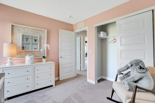 bedroom featuring light colored carpet, baseboards, visible vents, and a closet
