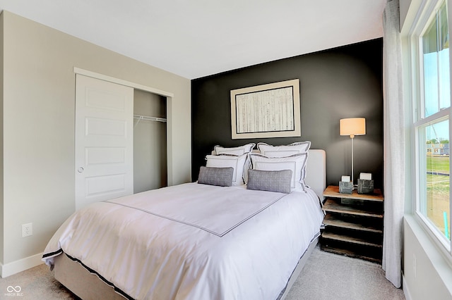 carpeted bedroom featuring a closet and baseboards