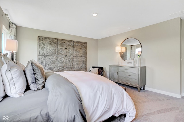 bedroom featuring light colored carpet and baseboards
