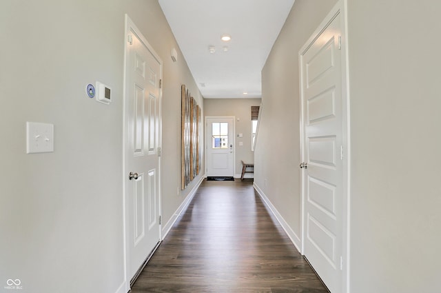 corridor featuring dark wood-style flooring, baseboards, and recessed lighting