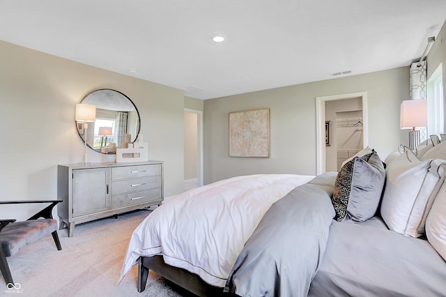 bedroom featuring visible vents, multiple windows, and light carpet