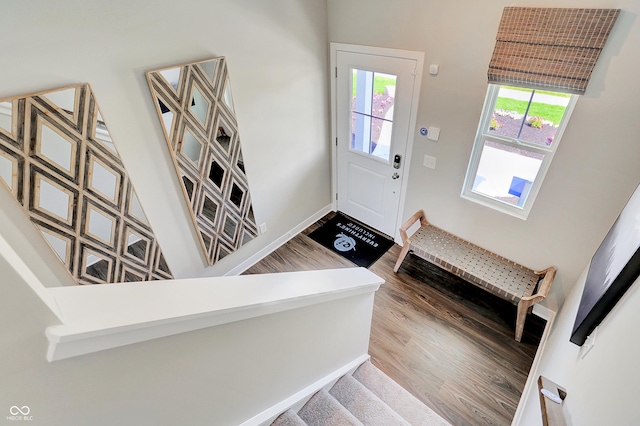 entryway with baseboards, stairs, and wood finished floors