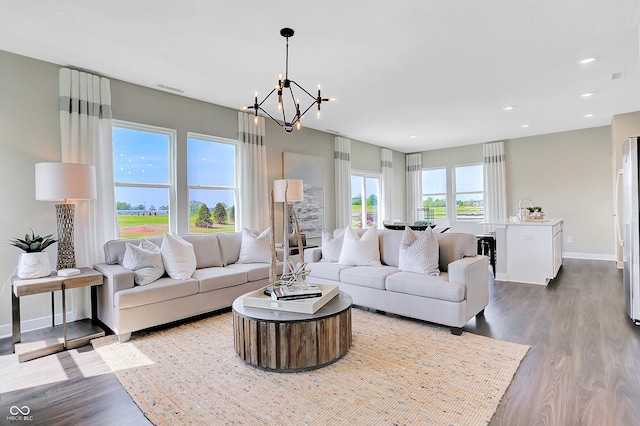 living room with baseboards, visible vents, dark wood-style flooring, and a notable chandelier