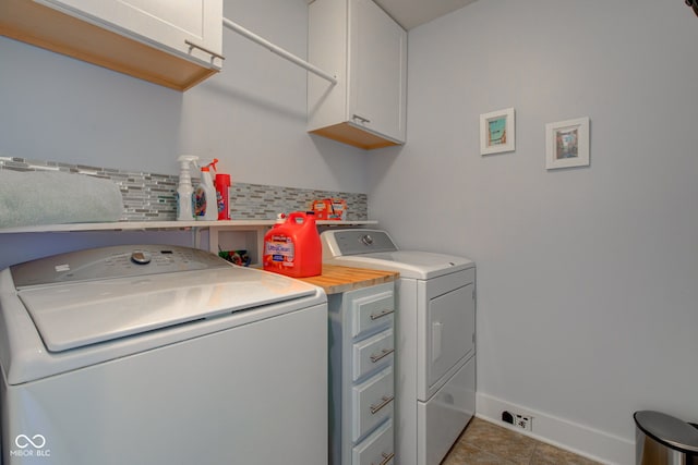washroom featuring tile patterned flooring, baseboards, cabinet space, and washing machine and dryer