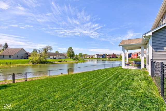 view of yard with a water view, fence, and a residential view