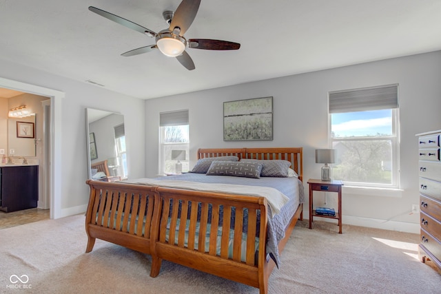 carpeted bedroom with connected bathroom, a ceiling fan, baseboards, and visible vents
