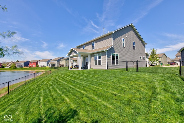 back of house with a yard, fence, and a residential view
