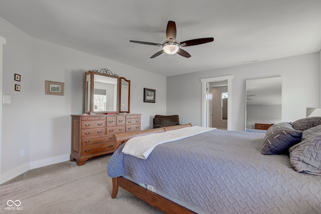 bedroom with baseboards, ceiling fan, and light carpet