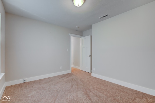 spare room featuring baseboards, carpet flooring, and visible vents