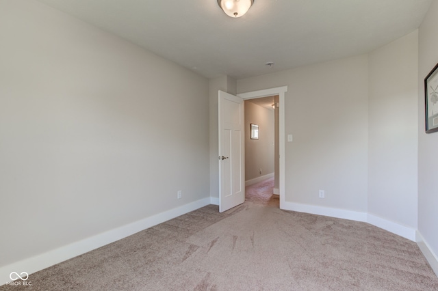 empty room with baseboards and light colored carpet