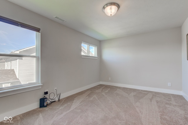 carpeted empty room with baseboards and visible vents