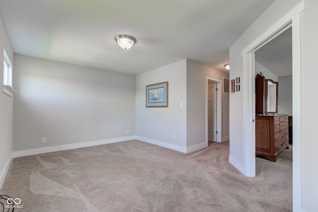 carpeted spare room featuring baseboards