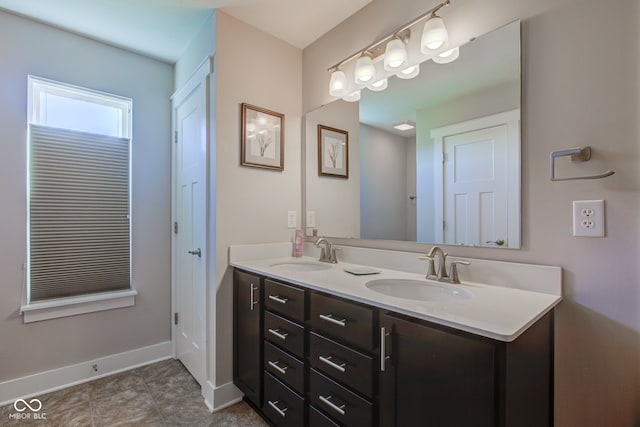 full bath with a sink, baseboards, tile patterned floors, and double vanity