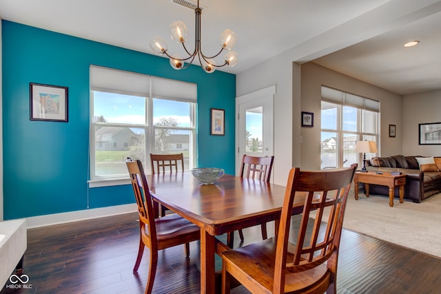 dining room featuring an inviting chandelier, dark wood finished floors, and baseboards