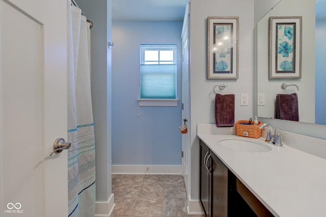 full bathroom with vanity and baseboards