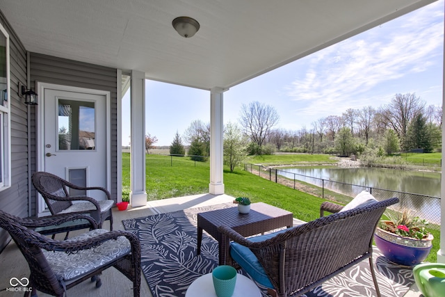view of patio / terrace featuring a porch, a water view, and fence
