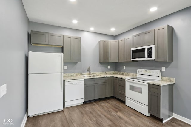 3098 Central, Arlington, IN 46104 - kitchen with wood finished floors, a sink, baseboards, gray cabinetry, and white appliances