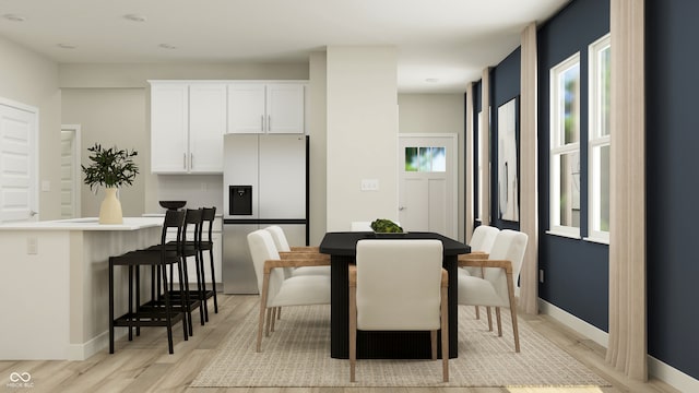 dining area with light wood-style floors and baseboards