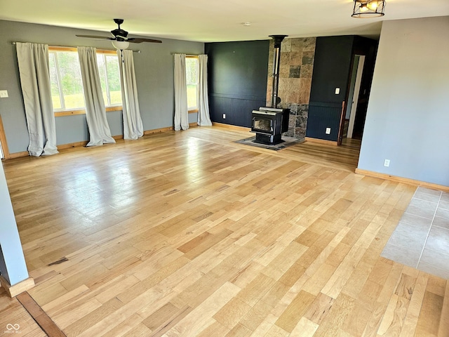 1647 State Ferry Rd, Solsberry, IN 47459 - unfurnished living room featuring light wood-style floors, baseboards, ceiling fan, and a wood stove