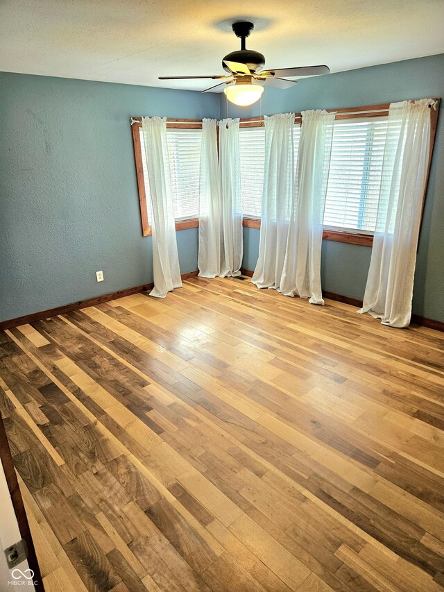 1647 State Ferry Rd, Solsberry, IN 47459 - spare room featuring wood-type flooring, baseboards, ceiling fan, and a textured wall
