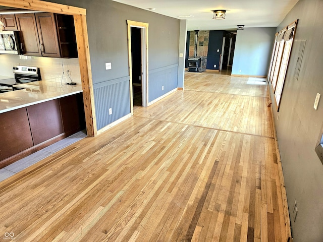 1647 State Ferry Rd, Solsberry, IN 47459 - kitchen featuring a wood stove, light wood-style floors, light countertops, stainless steel appliances, and open floor plan
