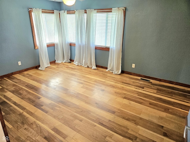 1647 State Ferry Rd, Solsberry, IN 47459 - unfurnished room with a textured wall, visible vents, baseboards, and hardwood / wood-style flooring