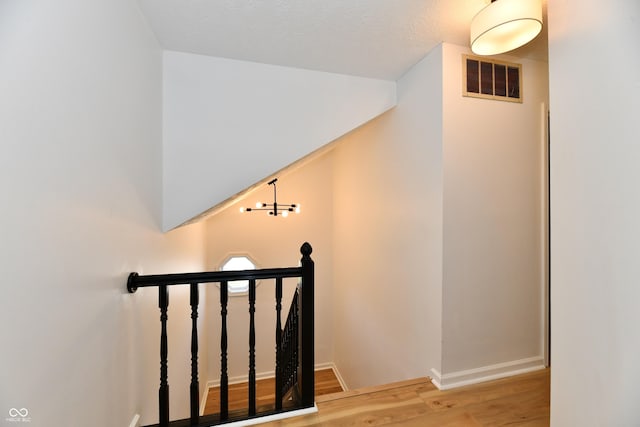 stairs featuring visible vents, baseboards, and wood finished floors