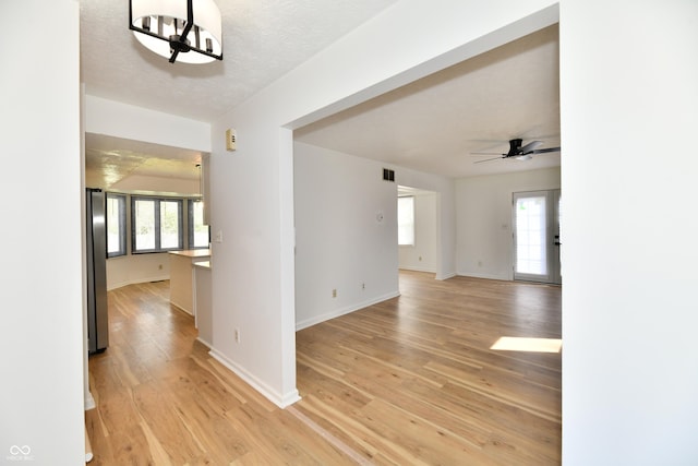 unfurnished room featuring baseboards, a ceiling fan, light wood-type flooring, and visible vents
