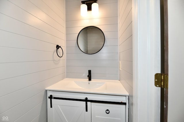 bathroom featuring wooden walls and vanity