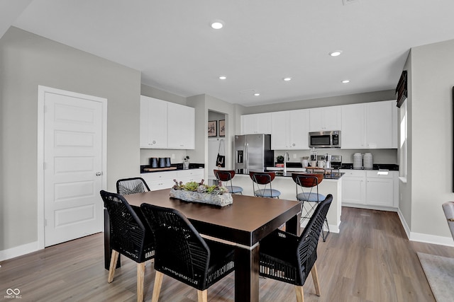 dining space with recessed lighting, baseboards, and light wood-type flooring