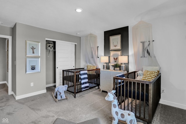 carpeted bedroom featuring a nursery area, baseboards, and a closet
