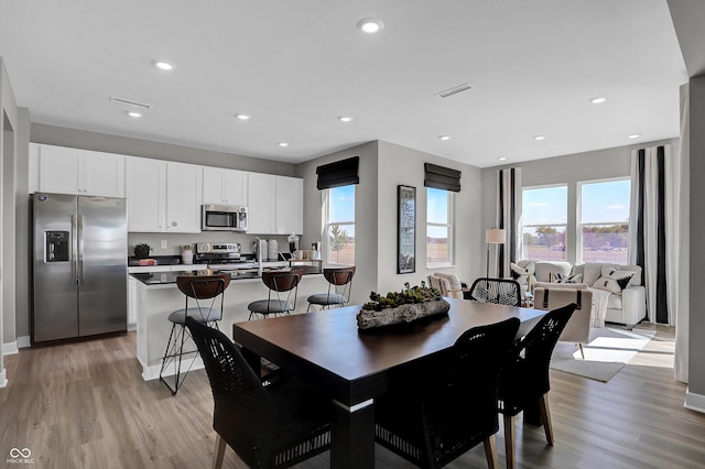 dining space featuring visible vents, recessed lighting, light wood-style flooring, and a healthy amount of sunlight