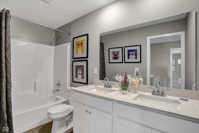 bathroom with a sink, shower / bath combo with shower curtain, toilet, and wood finished floors
