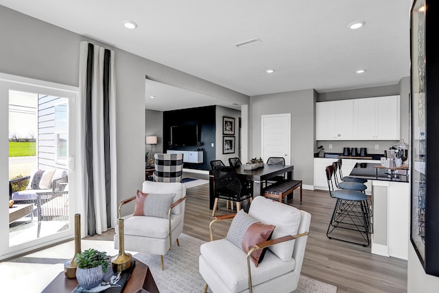 living room with visible vents, recessed lighting, baseboards, and wood finished floors