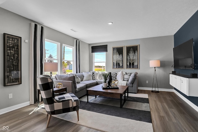 living room with baseboards, dark wood finished floors, and visible vents