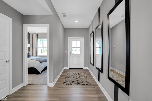 foyer featuring visible vents, baseboards, and wood finished floors