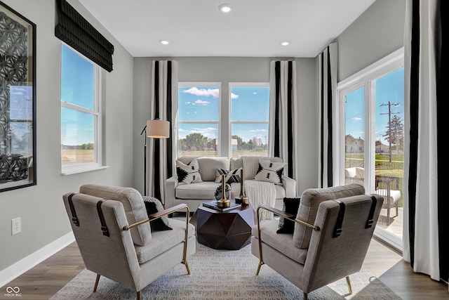 living area with recessed lighting, wood finished floors, and a healthy amount of sunlight