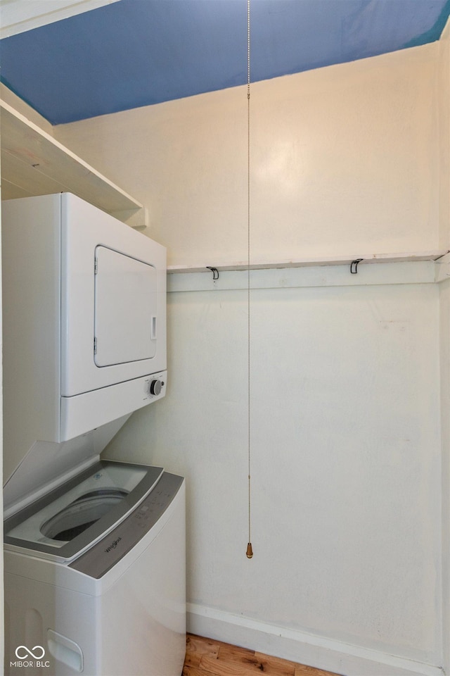 4710 Hinesley Ave, Indianapolis, IN 46208 - washroom featuring light wood-style floors, baseboards, stacked washer / drying machine, and laundry area