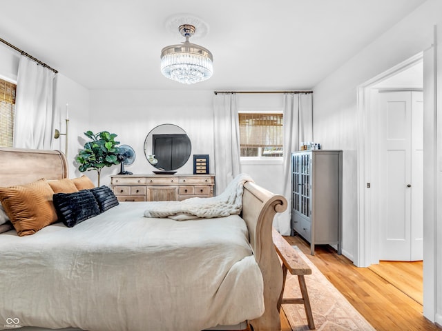 bedroom with wood finished floors and a chandelier