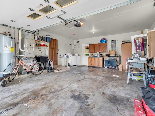 garage with a garage door opener, washer and clothes dryer, and electric water heater