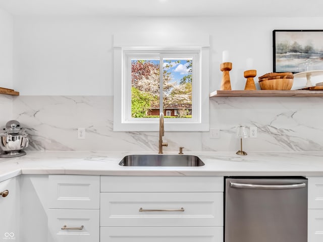 kitchen featuring a sink, backsplash, dishwasher, and white cabinets
