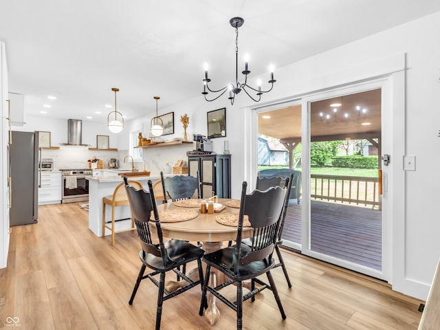 dining room with recessed lighting, light wood-style flooring, and a notable chandelier