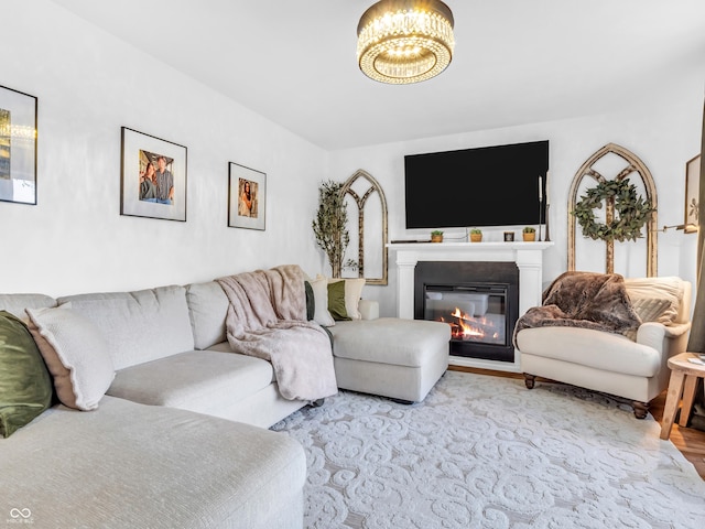 living area with a chandelier and a glass covered fireplace