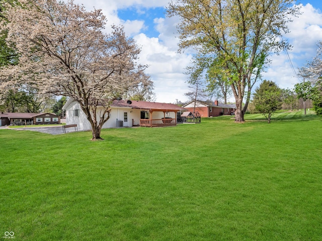 view of yard featuring central AC and a deck