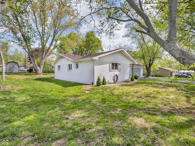 back of property with a lawn, brick siding, and a garage