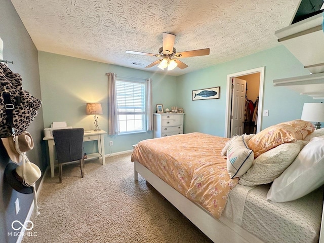 carpeted bedroom featuring visible vents, a textured ceiling, a ceiling fan, baseboards, and a spacious closet