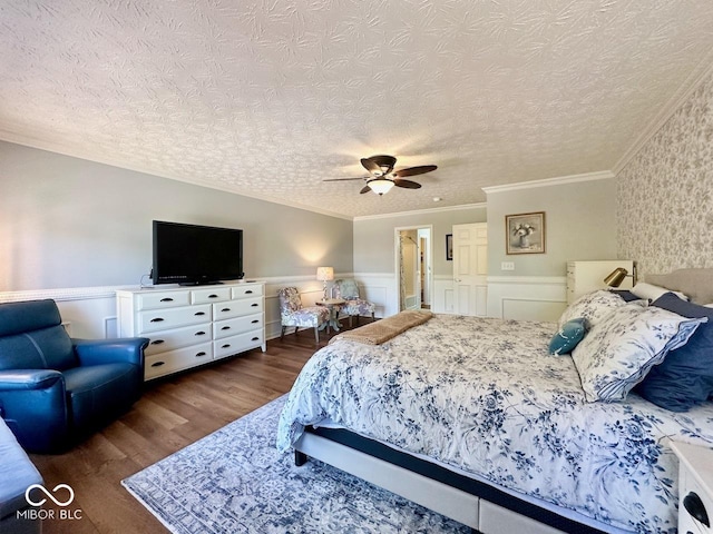 bedroom featuring ornamental molding, wainscoting, a textured ceiling, and wood finished floors